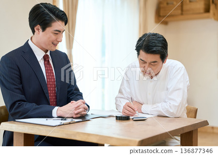 A man in the legal profession providing assistance with writing documents A man in the legal profession providing assistance with writing documents 136877346