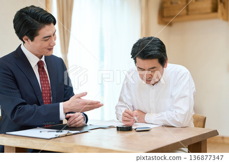 A man in the legal profession providing assistance with writing documents 136877347