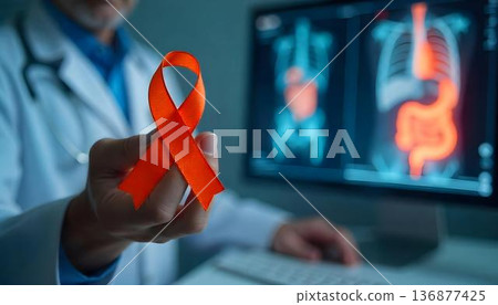 A healthcare professional showcases an orange ribbon in front of a computer, representing hope and awareness for leukemia patients 136877425