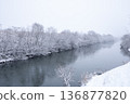 冬天，雪花輕輕飄落在河岸邊，樹木也被白雪覆蓋。 136877820