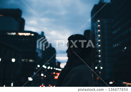 夜色中,一位女子的身影矗立在城市街頭。 夜色中,一位女子的身影矗立在城市街頭。 136877850