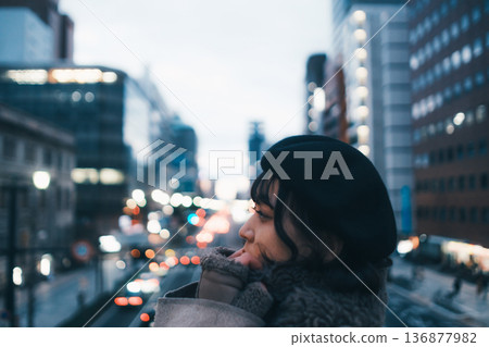 A Japanese woman in her 30s lost in thought in the city at night A Japanese woman in her 30s lost in thought in the city at night 136877982