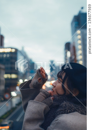 A Japanese woman in her 30s lost in thought in the city at night A Japanese woman in her 30s lost in thought in the city at night 136877989