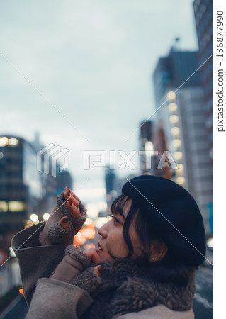 A Japanese woman in her 30s lost in thought in the city at night 136877990