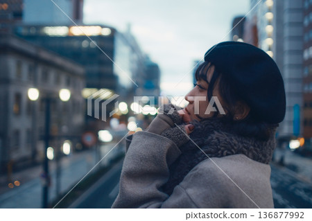 A Japanese woman in her 30s lost in thought in the city at night 136877992