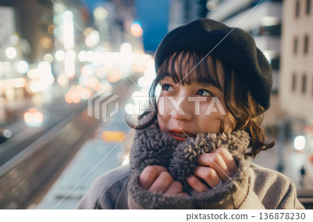 A Japanese woman in her 30s quietly closing her eyes in the city at night 136878230