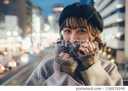 A Japanese woman in her 30s quietly closing her eyes in the city at night 136878240
