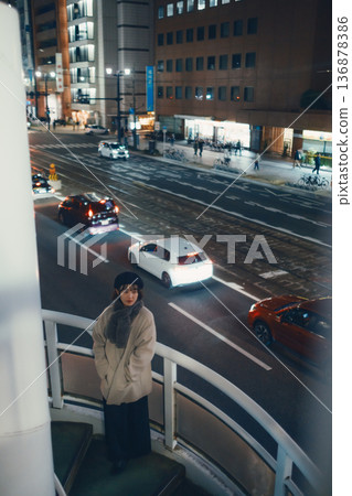 一位日本女子夜間站在人行天橋上。 一位日本女子夜間站在人行天橋上。 136878386