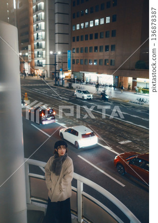 一位日本女子夜間站在人行天橋上。 一位日本女子夜間站在人行天橋上。 136878387