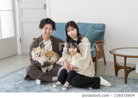Smiling young family and their two pet dogs looking at the camera 136878604