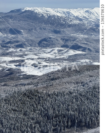 Winter snow-covered forest and mountain landscape with a quiet valley panorama Winter snow-covered forest and mountain landscape with a quiet valley panorama 136878610