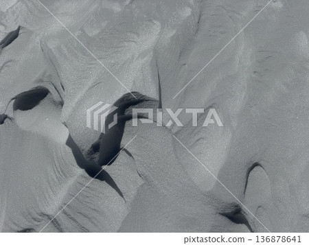 Wind-sculpted snow texture with soft shadows and abstract winter patterns on alpine slope 136878641