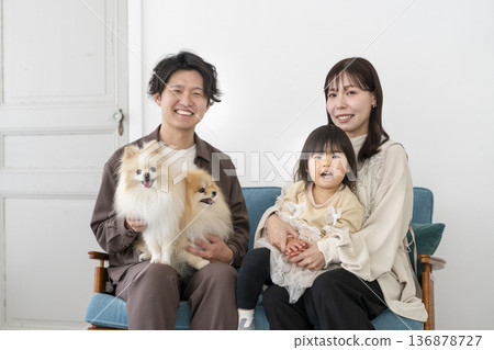 笑容燦爛的年輕家庭和他們的兩隻寵物狗正看著鏡頭。 笑容燦爛的年輕家庭和他們的兩隻寵物狗正看著鏡頭。 136878727