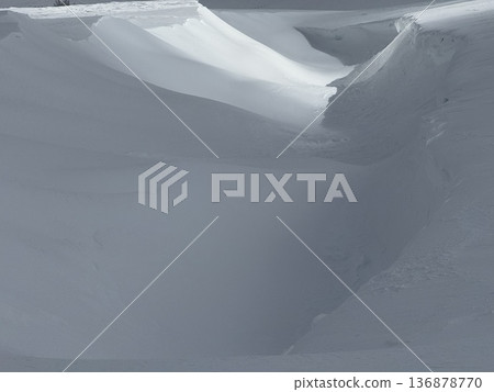 Deep snowdrift and carved snow field with soft light creating an abstract winter landscape of textures Deep snowdrift and carved snow field with soft light creating an abstract winter landscape of textures 136878770
