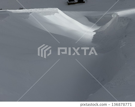 Snow drift and sculpted snowbank in a quiet winter landscape with soft light and shadows 136878771
