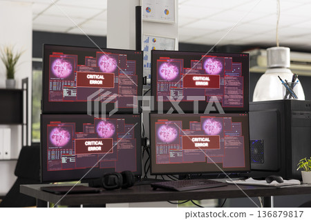 Desktop monitors show system error warnings in empty office workspace. The scene represents software failure, technical issues and business interruption in modern IT environment. Desktop monitors show system error warnings in empty office workspace. The scene represents software failure, technical issues and business interruption in modern IT environment. 136879817
