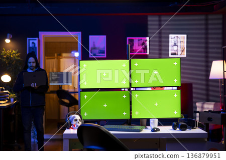 Man entering apartment, hacking using green screens PC, stealing credit card numbers and infiltrating banking systems. Hacker arriving in secret hideout, running code on mockup computer displays Man entering apartment, hacking using green screens PC, stealing credit card numbers and infiltrating banking systems. Hacker arriving in secret hideout, running code on mockup computer displays 136879951