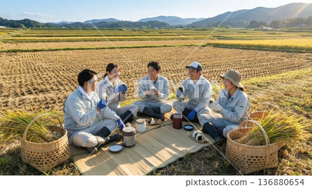 A group of young farmers eating rice balls in a rice field after harvest 136880654