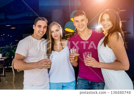 Cheerful friends in the pub. Drinking beer, talking, having fun. Cheerful friends in the pub. Drinking beer, talking, having fun. 136880748