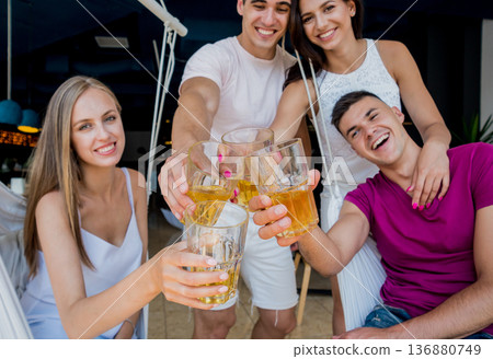 Cheerful friends in the pub. Drinking beer, talking, having fun. Cheerful friends in the pub. Drinking beer, talking, having fun. 136880749