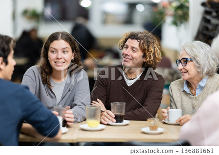 Large friendly family gathered at table to have meeting in restaurant Large friendly family gathered at table to have meeting in restaurant 136881661