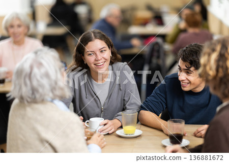 Large family is having breakfast in a cozy cafe, discussing news. Large family is having breakfast in a cozy cafe, discussing news. 136881672