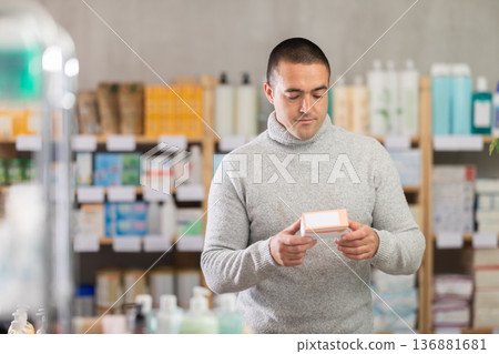 Man carefully selects pills in modern pharmacy Man carefully selects pills in modern pharmacy 136881681