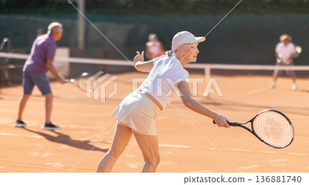 Elderly couple playing tennis together on summer court 136881740