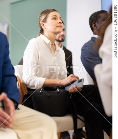 In business lesson, woman student listens to lecture and watch to presentation slides In business lesson, woman student listens to lecture and watch to presentation slides 136881890