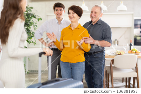 Parents and son joyfully greet their daughter and sister, who came from far away Parents and son joyfully greet their daughter and sister, who came from far away 136881955