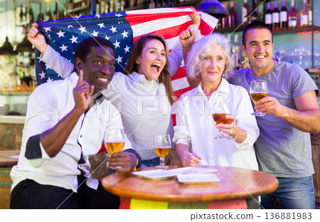 Emotional multiracial american spots supporters with flag of USA happy about victory in championship Emotional multiracial american spots supporters with flag of USA happy about victory in championship 136881983