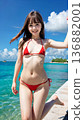Smiling young woman in bikini swimsuit on summer beach 136882001