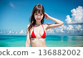 Smiling young woman in bikini swimsuit on summer beach 136882002