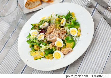 Tuna salad with avocado, eggs and greens on ceramic plate Tuna salad with avocado, eggs and greens on ceramic plate 136882100