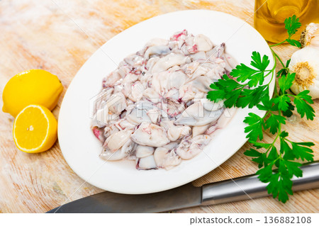 Raw baby squid with condiments ready for preparation Raw baby squid with condiments ready for preparation 136882108