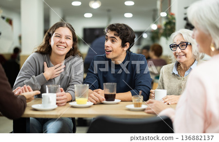 older generation of the family communicates with their grandchildren in a cafe 136882137