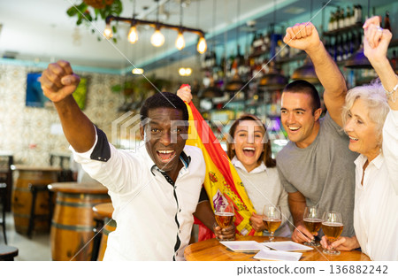 Excited multicultural football fans celebrate goal score of their team with hands up at pub Excited multicultural football fans celebrate goal score of their team with hands up at pub 136882242