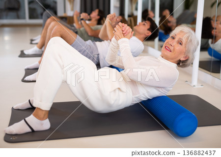 Elderly woman doing pilates with roller Elderly woman doing pilates with roller 136882437