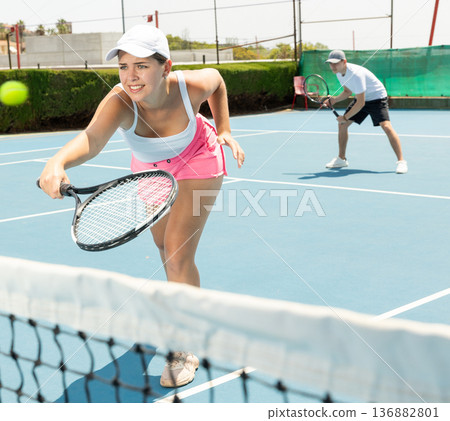 Portrait of young beautiful female tennis player about to serve ball. Portrait of young beautiful female tennis player about to serve ball. 136882801