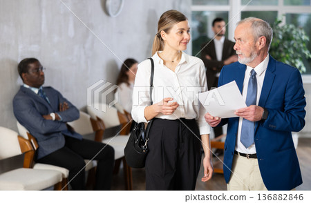 Adult woman talking to elderly man in the hallway about vacancies 136882846