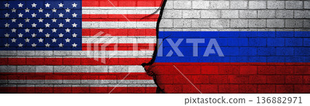Conceptual image showing American and Russian flags on a cracked brick wall, symbolizing geopolitical tension, conflict, and strained international relations between the two superpowers Conceptual image showing American and Russian flags on a cracked brick wall, symbolizing geopolitical tension, conflict, and strained international relations between the two superpowers 136882971