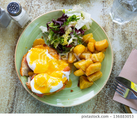 Portion of eggs benedict toast with salmon and potatoes closeup Portion of eggs benedict toast with salmon and potatoes closeup 136883053