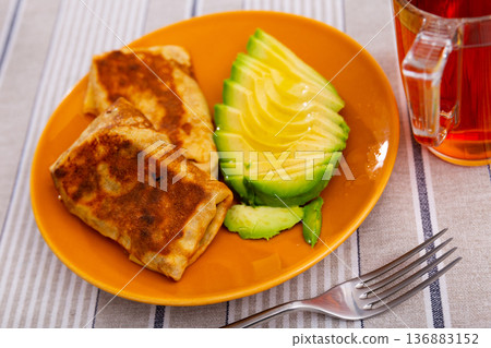 Pancakes stuffed with liver and egg with avocado Pancakes stuffed with liver and egg with avocado 136883152