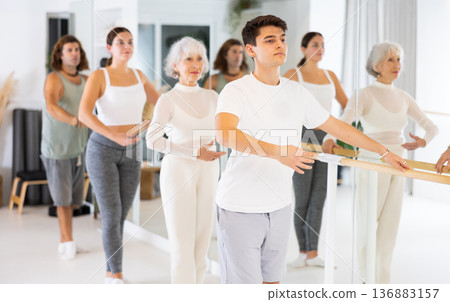 Group of different people doing ballet at barre Group of different people doing ballet at barre 136883157
