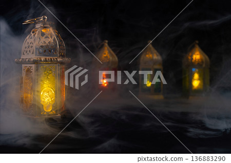 Ornamental Arabic lantern with burning candle glowing at night. Festive greeting card Ornamental Arabic lantern with burning candle glowing at night. Festive greeting card 136883290