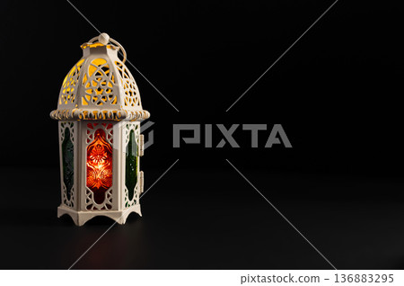 Ornamental Arabic lantern with burning candle glowing at night. Festive greeting card Ornamental Arabic lantern with burning candle glowing at night. Festive greeting card 136883295