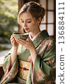 Western woman wearing a kimono drinking matcha tea 136884111
