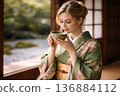 Western woman wearing a kimono drinking matcha tea 2 136884112