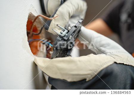 Electrician wiring light switches with protective gloves 136884563