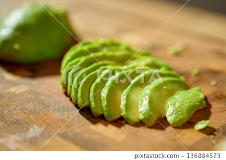 Avocado Slices on Wooden Cutting Board 136884573